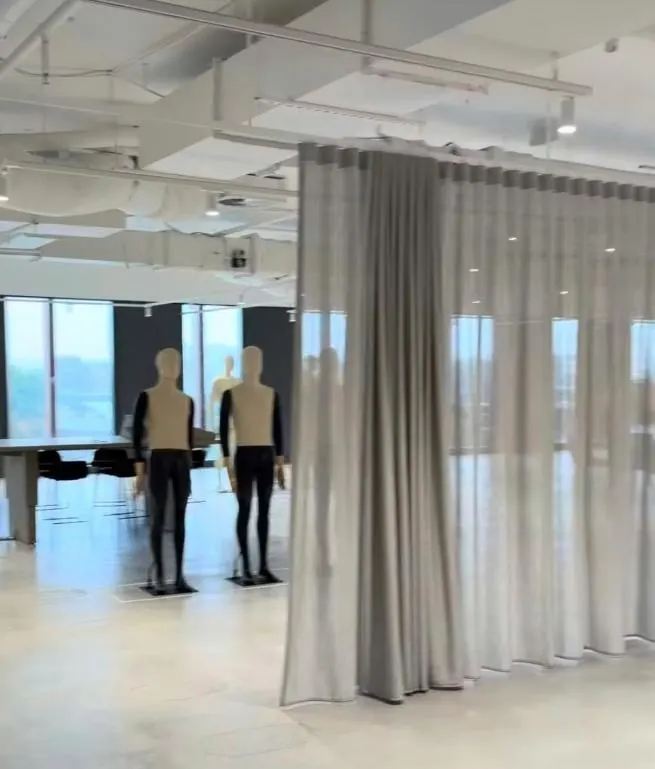 Suspended partition curtain dividing a commercial space