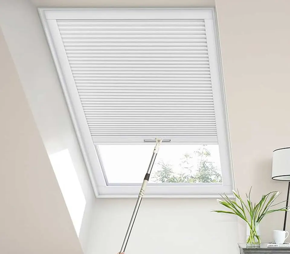 Honeycomb skylight blind in a sloped ceiling, operated by a pole