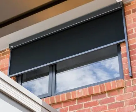 Dark fabric awning over a window on a brick home