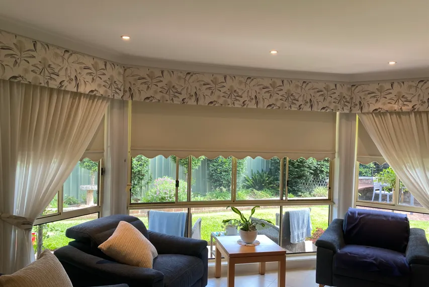 Upholstered pelmet across a bay window with sheers and blinds
