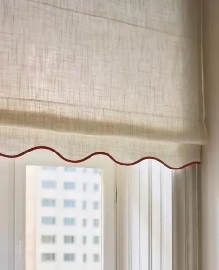 Structured sheer Roman blind with a piped, scalloped valance