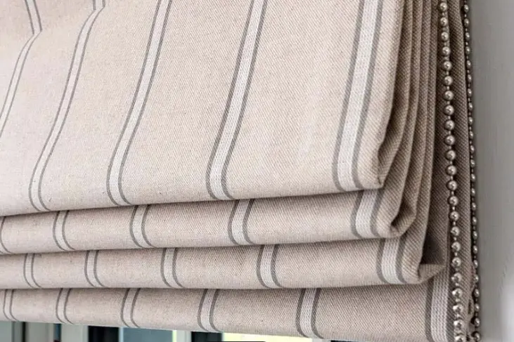Striped blockout Roman blind with a studded edge trim