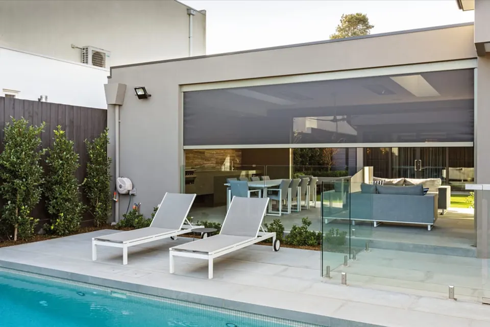 Zip screen lowered across an alfresco area beside a pool